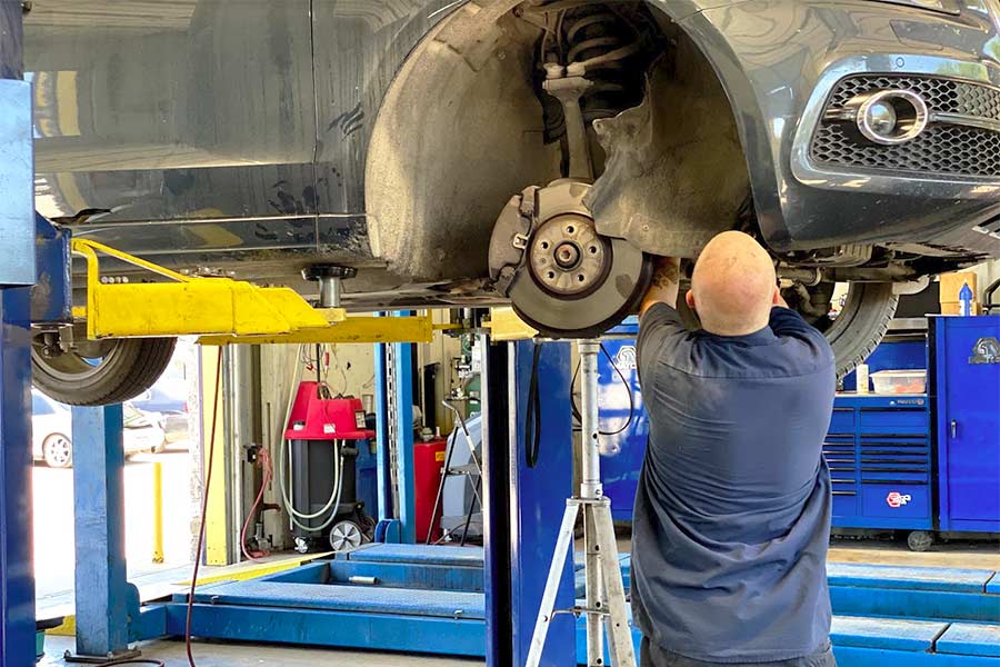 A technician adjusts a vehicle's wheel alignment.