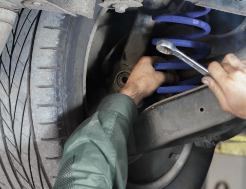 Mechanic adjusting a car suspension