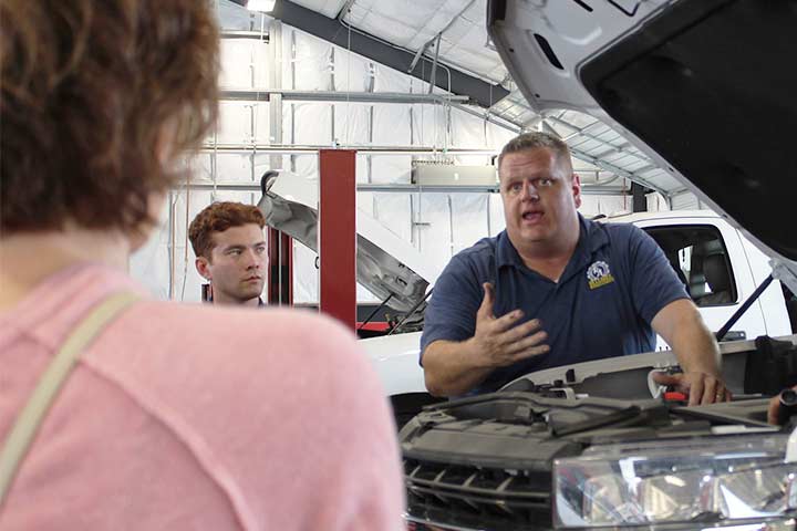 A service technician educates a customer on her vehicle's repairs.
