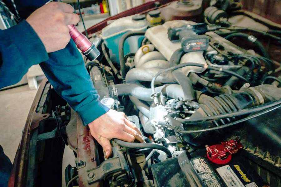 A mechanic inspecting the engine of a used car