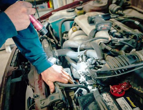 A mechanic inspecting the engine of a used car