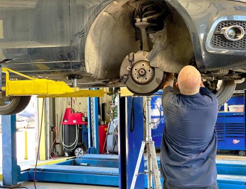 A technician adjusts a vehicle's wheel alignment.