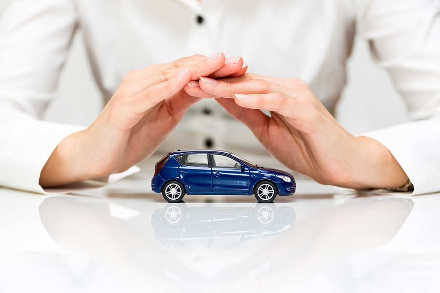 Hands covering a toy SUV to illustrate warranty coverage