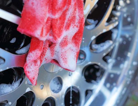 Soap-covered microfiber cloth on a car's wheel