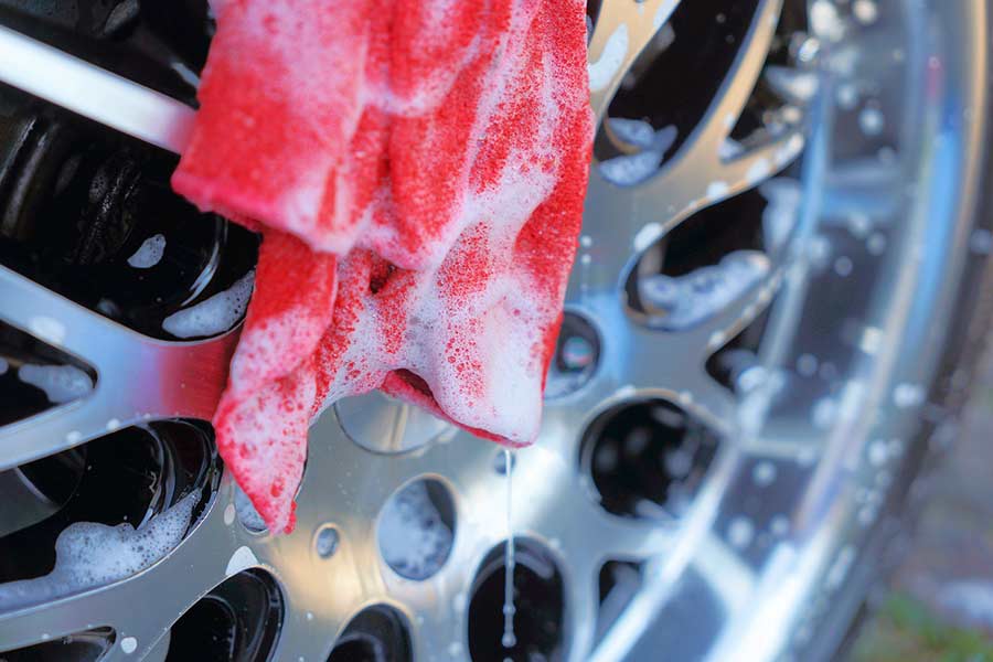 Soap-covered microfiber cloth on a car's wheel