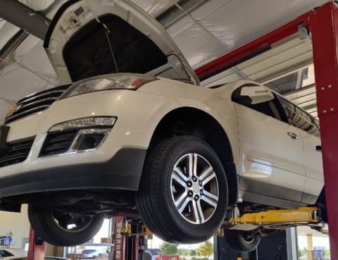White SUV on suspension equipment in mechanic shop