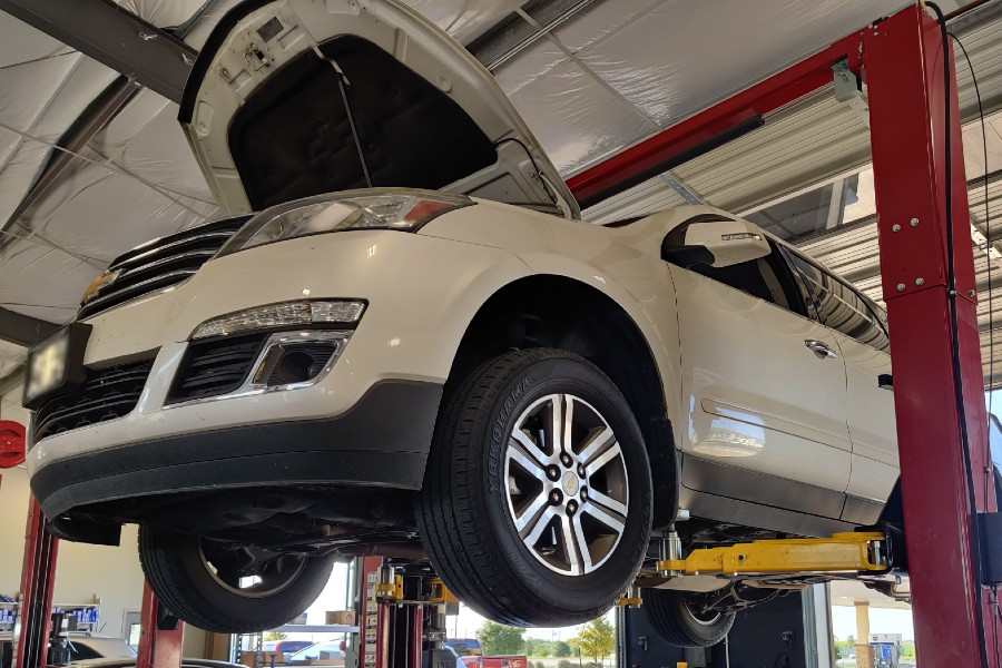 White SUV on suspension equipment in mechanic shop