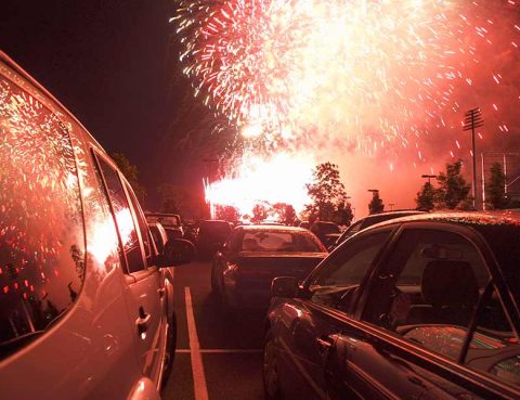 Fireworks reflecting off a vehicle's window