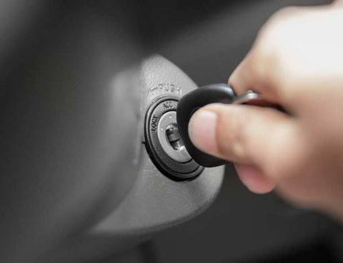 Hand turning a key in a vehicle's ignition