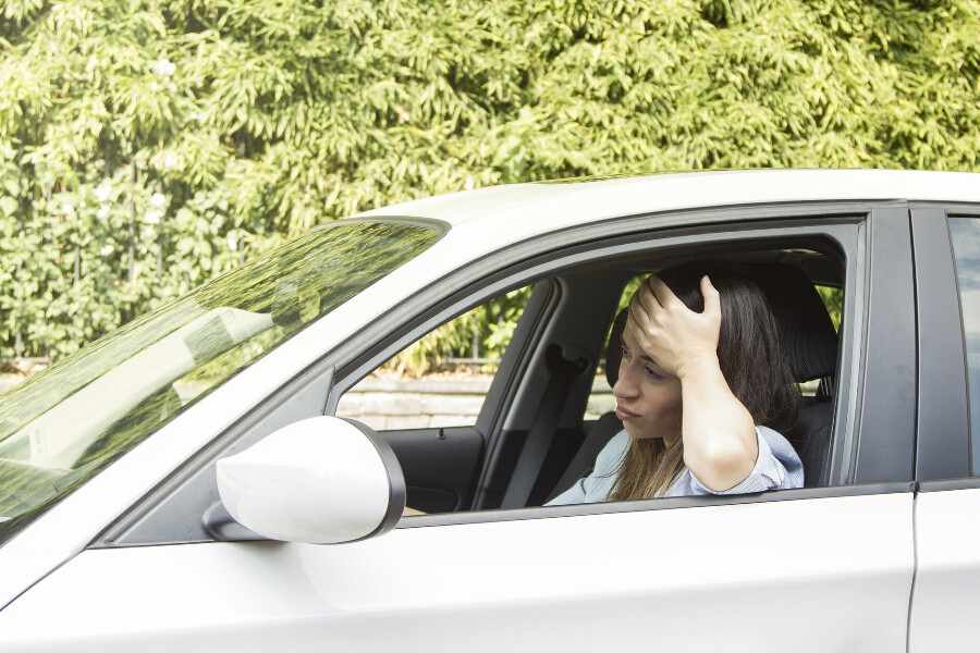 A woman frustrated that her car jerks while accelerating.