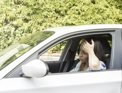 A woman frustrated that her car jerks while accelerating.
