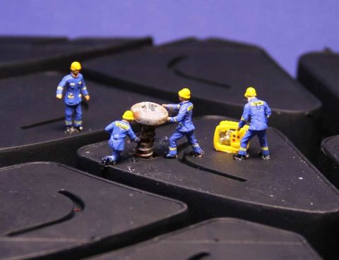 Miniature figures repairing a tire