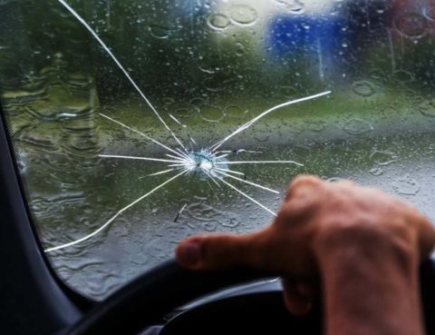 person driving in the rain with a chipped windshield - Windshield & Auto Glass replacement or repair in Buda & Kyle Tx.