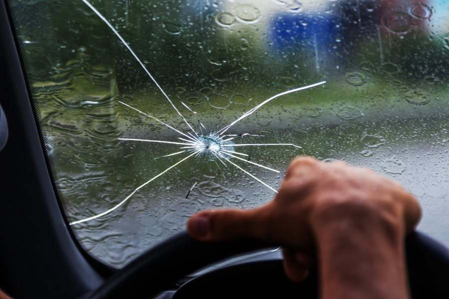 person driving in the rain with a chipped windshield - Windshield & Auto Glass replacement or repair in Buda & Kyle Tx.