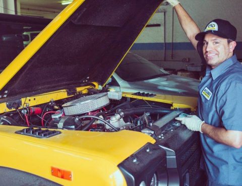friendly neighborhood mechanic doing repairs on a yellow vehicle - Automotive Shop for Fast Auto Repair & Oil Change in San Marcos, Kyle, and Buda, Tx