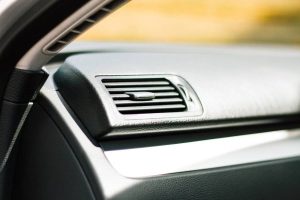 Close-up of a gray A/C vent on a car's dashboard