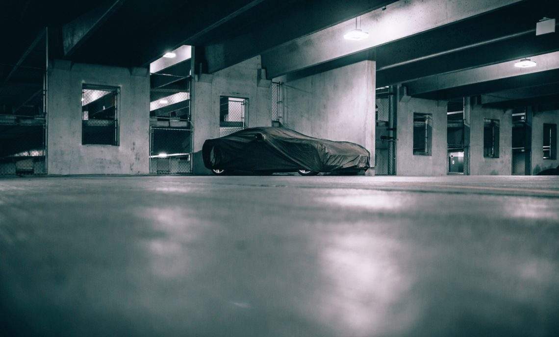 car that is not often used covered with a car cover in a garage