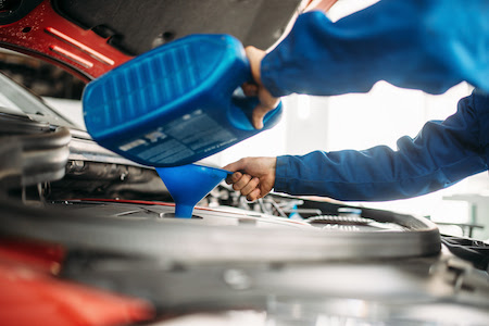 auto mechanic performing an oil change service